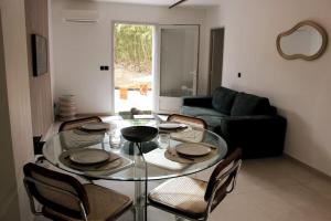 ein Wohnzimmer mit einem Glastisch und Stühlen in der Unterkunft Superbe Appartement avec Clim/Terrasse/Parking in Montpellier