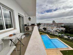 balcón con mesa y piscina en Albufeira Vintage Apartment With Pool by Homing en Albufeira