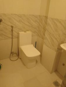 a white bathroom with a toilet and a sink at Hotel aradhya in Lumbini