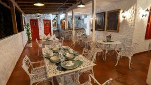 un comedor con mesas y sillas blancas en BALCÓN DEL CIELO eco hotel glamping, en Frailes