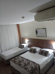 a hotel room with two beds and two lamps at HOTEL condomínio EDIFÍCIO COMFORT TAGUATINGA FLAT in Taguatinga