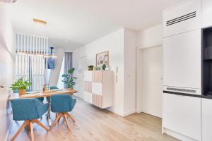 uma cozinha e sala de jantar com mesa e cadeiras em Wave Family Apartment - Sea View em Międzyzdroje