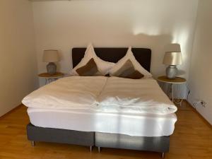a bedroom with a white bed with two side tables at Annahof in Argenbühl