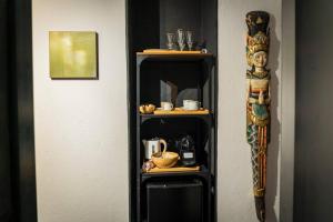 a black book shelf with items on it next to a wall at Suite 180° - Lago di Como in Blevio