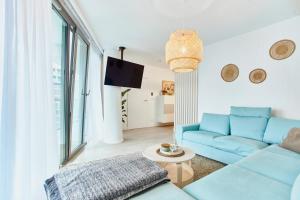 a living room with a blue couch and a table at Wave Family Apartment - Sea View in Międzyzdroje