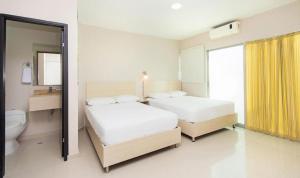 a hotel room with two beds and a bathroom at Ribai Hotels -Riohacha in Ríohacha