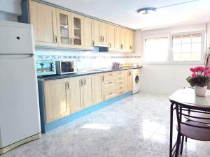 uma cozinha com um frigorífico branco e uma mesa em Apartamento Munay en Playa Albir em Foyes Blanques