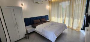 a bedroom with a large bed with a blue headboard at Riverside Farm in Murud
