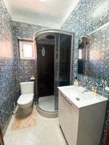ein Bad mit einem WC, einer Dusche und einem Waschbecken in der Unterkunft GH Odivelas - Quartos em Casa com Bilhar! 
