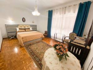 a bedroom with a bed and a table and a chair at GH Odivelas - Quartos em Casa com Bilhar! 