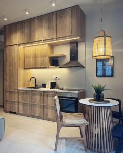 eine Küche mit Holzschränken und einem Tisch mit einem Stuhl in der Unterkunft Luxurious wooden detail flat in city center in Chalkida