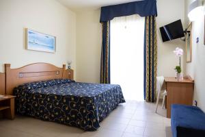 a bedroom with a bed and a large window at Blu Salento Village in Sant'Isidoro