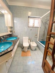 的住宿－GH Odivelas - Quartos em Casa com Bilhar!，浴室配有2个盥洗盆、卫生间和浴缸。