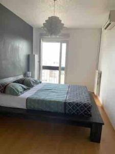 um quarto com uma cama e uma janela em Appartement 3 chambres à Pont de Claix em Le Pont-de-Claix