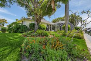a house with a garden in front of it at Serene canal, three bedrooms and a large pool! - Villa La Brisa Fresca in Cape Coral