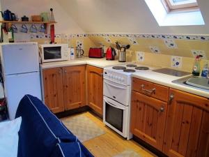 a kitchen with a white stove and a microwave at Fisherman's Cottage in Tobermory