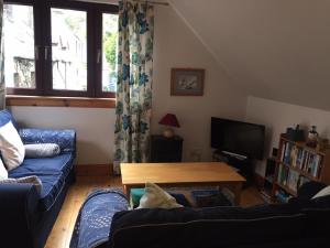a living room with a blue couch and a table at Fisherman's Cottage in Tobermory