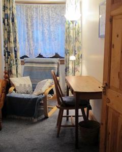 um quarto com uma secretária, uma mesa e uma cadeira em Fisherman's Cottage em Tobermory