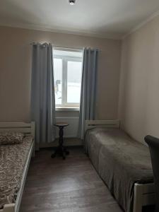 a bedroom with two beds and a window at Apartment in Kovelʼ