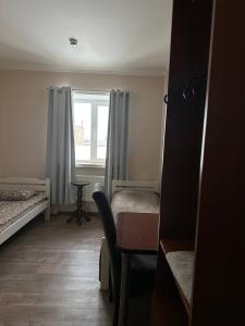 a bedroom with a bed and a desk and a window at Apartment in Kovelʼ