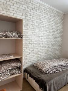 1 dormitorio con 2 literas y pared de ladrillo en Apartment en Kovelʼ