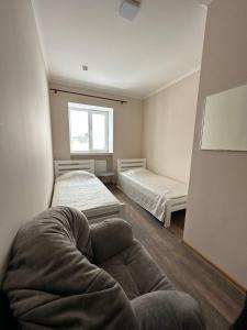 a room with two beds and a couch in it at Apartment in Kovelʼ