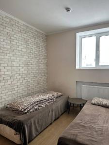 1 Schlafzimmer mit 2 Betten und Ziegelwand in der Unterkunft Apartment in Kowel