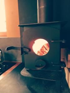 - une cuisine équipée d'une cuisinière et d'une cheminée dans l'établissement Roulotte dans les Ardennes, à Belval