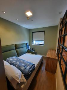 a bedroom with a bed and a table and a window at FLAT HOTEL DOIS QUARTOS AV IBIRAPUERA 2927 in Sao Paulo