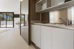 uma cozinha com armários brancos e um lavatório em Grand Studio Valeriane em Trans-en-Provence