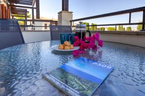 a table with a plate of food and a book on it at 2 bedroom Apartment Assia with communal pool, Aphrodite Hills Resort in Kouklia