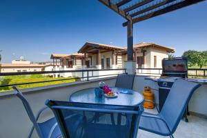 a table and chairs on a balcony with a stove at 2 bedroom Apartment Assia with communal pool, Aphrodite Hills Resort in Kouklia