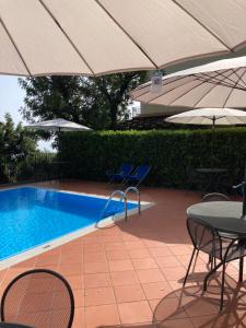 een zwembad met stoelen, tafels en parasols bij Il Casalino in Maratea
