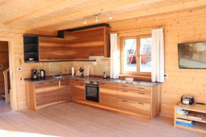 a kitchen with wooden cabinets and a window in a cabin at Unterplattnerhof in Chiusa