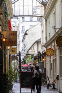 a person walking down a narrow street with buildings at Hôtel Saint-André des Arts in Paris