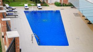 a large blue swimming pool with chairs and tables at The B Hotel in Kigali