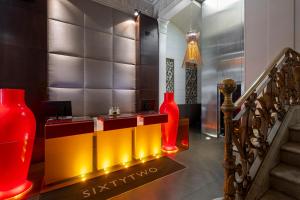 - un hall avec des vases et des escaliers rouges et jaunes dans l'établissement Sixtytwo Hotel, à Barcelone