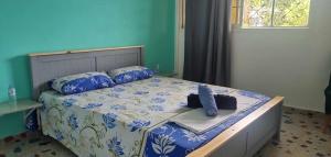 a bed with blue and white sheets and pillows at STARALOGE in Pamandzi