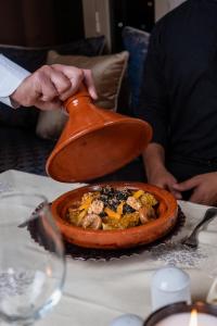 una persona tiene un cucchiaio sopra un piatto di cibo di Kenzi Menara Palace & Resort a Marrakech