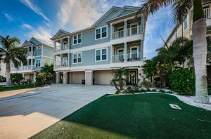 a large house with a driveway and palm trees at Tropical Treasure Beach Villa in St. Pete Beach