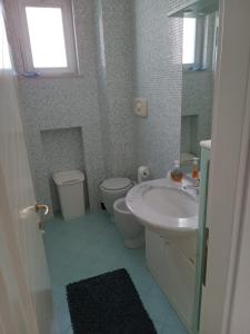 ein Bad mit einem Waschbecken, einem WC und einem Fenster in der Unterkunft Casa di Giorgio in Pesaro