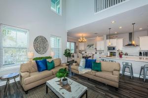 a living room with two couches and a kitchen at Tropical Treasure Beach Villa in St. Pete Beach