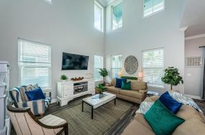 a living room with a couch and chairs and a tv at Tropical Treasure Beach Villa in St. Pete Beach