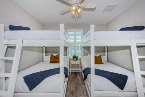 two bunk beds in a room with a ceiling fan at Tropical Treasure Beach Villa in St. Pete Beach