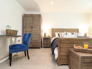 a bedroom with a bed and a blue chair at 31 Cliff Edge in Newquay