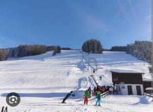 un grupo de personas en un remonte en la nieve en Auszeit auf dem Land, en Maierhöfen