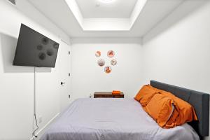 Schlafzimmer mit einem Bett mit orangefarbenem Kissen in der Unterkunft Stylish & Chic Experience in JC in Jersey City