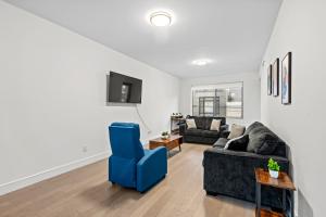 a living room with a couch and a blue chair at Stylish & Chic Experience in JC in Jersey City