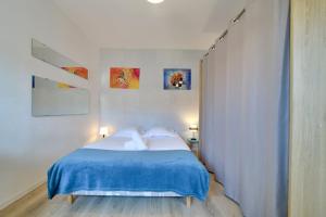 1 dormitorio con 1 cama con manta azul en Cosy apartment 10min from the metro Parking, en Lille