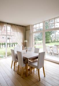 a dining room with a table and white chairs at Gite de charme proche de Lille - La Conciergerie in Sainghin-en-Mélantois
